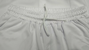 Detalle de pantalones cortos deportivos de malla blanca con cintura elástica y cordón