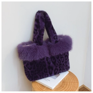 Détail d'un sac à main en fausse fourrure léopard violet posé sur un tabouret en bois