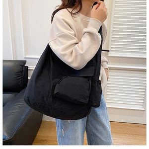 Side view of a black large-capacity nylon shoulder bag with multiple functional pockets