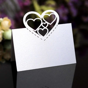 Macro detail of laser-cut heart pattern on pearlescent white wedding place cards