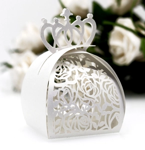 Close-up of laser-cut crown handle and rose pattern on white wedding favor gift box