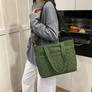 Détail du sac cabas matelassé en nylon vert armée avec large bandoulière amovible porté