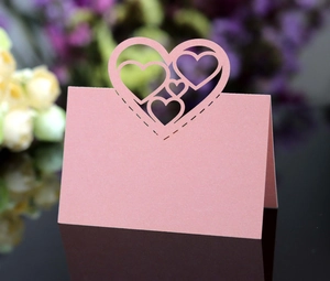 Close-up of pink laser-cut hollow heart table card with glittery pearlescent finish