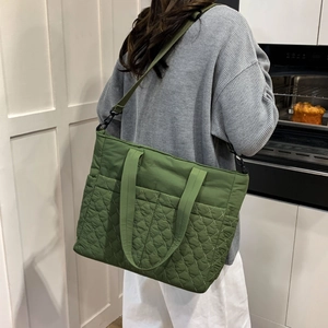Détail du sac fourre-tout matelassé vert herbe avec bandoulière sur un mannequin