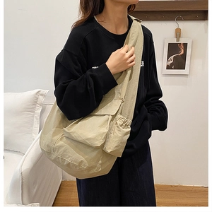 Detail of khaki large tote bag featuring side drawstring pocket and wide shoulder strap