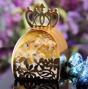 Detail of laser-cut gold crown gift box with intricate floral patterns for weddings