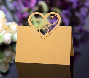 Close-up of elegant hollow heart-shaped gold-brown place card for wedding table decor