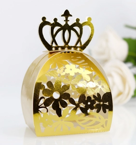 Macro detail of laser-cut floral pattern and golden crown decoration on wedding favor box