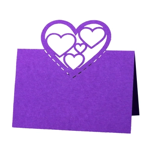 Close-up of laser-cut purple heart-shaped table place card with intricate hollow pattern