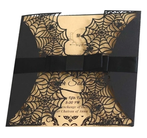 Detail of laser-cut black spider web invitation with silk ribbon and inner card