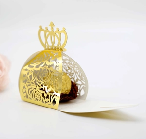 Detail of gold crown hollow candy box with rose laser-cut patterns for wedding favors
