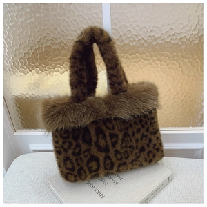Détail du sac cabas léopard en fausse fourrure avec bordure pelucheuse sur un livre