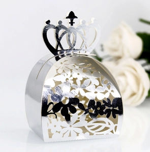 Close-up of laser-cut crown favor box with intricate floral hollow pattern in silver finish