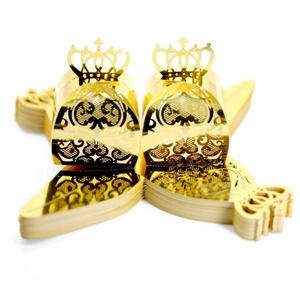 Detailed view of golden laser-cut hollow candy boxes with elegant crown topper decor
