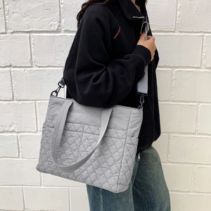 Photo extérieure d'un sac cabas gris matelassé avec bandoulière et poche latérale