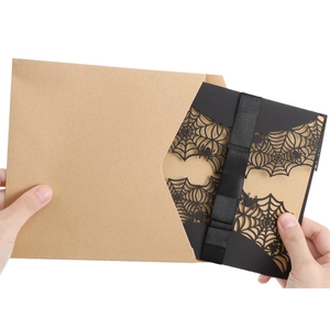 Detailed laser cut spider web invitation with black satin ribbon and kraft envelope