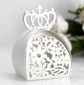 Detail of laser-cut crown gift box with intricate white floral patterns for weddings