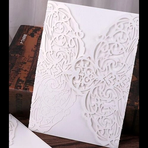 Elegant laser-cut white wedding invitation card with European lace pattern on vintage book