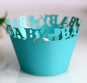 Detailed laser-cut baby carriage design on light blue cupcake wrapper for baby shower