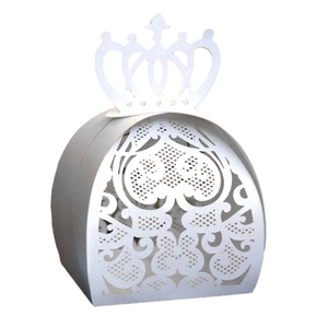 Macro view of white laser-cut wedding candy box with elegant crown and heart patterns
