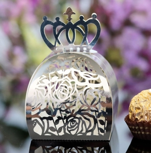 Macro detail of silver hollow crown candy box with intricate rose patterns and mirror finish