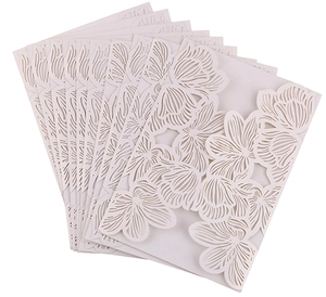 Close-up of laser cut floral wedding invitation covers in off-white stacked elegantly