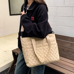 Détail du sac cabas beige matelassé avec motif losanges et bandoulière rose amovible