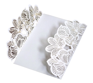 Close-up of laser-cut white wedding invitation cover with elegant rose floral hollow pattern