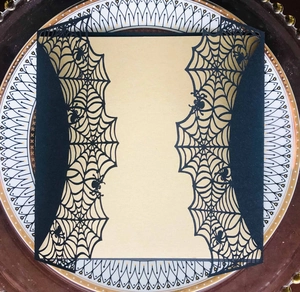 Laser-cut black spider web invitation cover with detailed Halloween spider motif