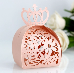 Macro shot of laser-cut crown gift box with intricate floral patterns and pink finish