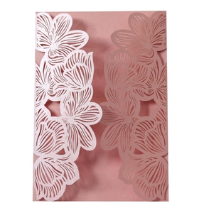 Macro detail of laser cut floral pattern on pink pearlescent paper invitation card
