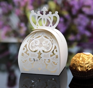 Macro shot of laser-cut crown candy box with intricate floral patterns on black mirror