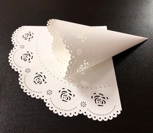 Laser-cut white rose lace paper cone with intricate floral patterns for wedding favors