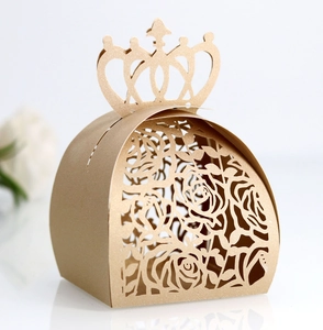 Detail of laser-cut gold wedding favor box with crown top and rose hollow pattern