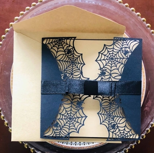 Gothic laser-cut spider web invitation set with black satin bow and kraft envelope