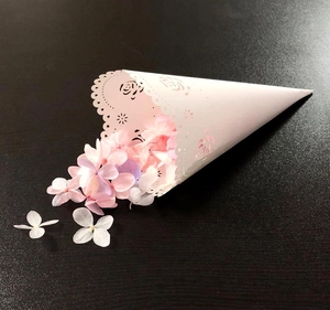 Detailed close-up of a white lace laser-cut paper cone filled with colorful dried petals
