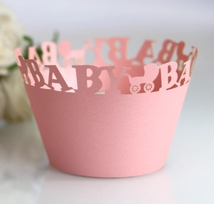 Detail of pink laser-cut cupcake wrapper with BABY text and stroller pattern