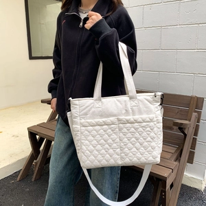 Détail d'un sac cabas blanc matelassé en nylon avec une bandoulière réglable pratique
