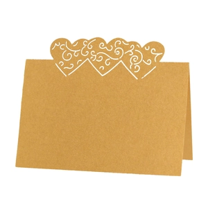 Detail view of heart-shaped laser-cut hollow pattern on brown kraft paper place cards
