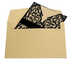 Laser-cut black wedding invitation set with ornate filigree, kraft envelope, and velvet belt