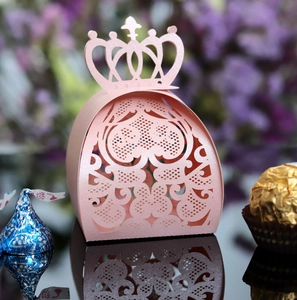 Laser-cut pink crown candy box with intricate floral patterns and glossy reflection