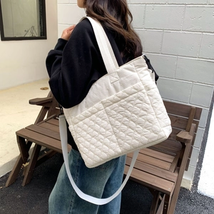 Détail du sac fourre-tout matelassé avec texture beige et bandoulière réglable