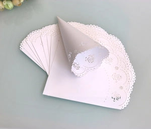 Detailed laser-cut white paper cones for wedding confetti and rose petal holder