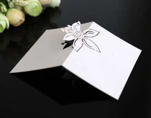 Detail of 3D laser-cut lily flower design on a white wedding table place card