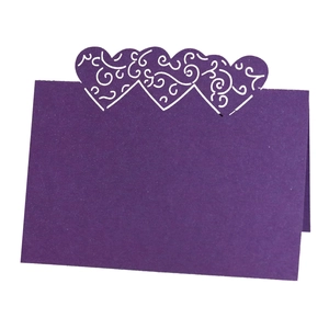 Detail of purple pearlescent place card with laser-cut heart pattern for wedding table