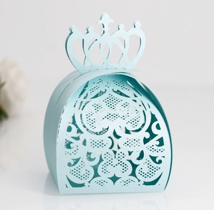 Macro shot of laser-cut heart details and 3D crown on pearlized blue wedding favor box