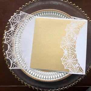 Detail of laser cut white spider web greeting card with golden kraft paper insert for Halloween