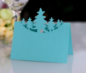 Detail of light blue laser cut Christmas tree place card with 3D hollow design