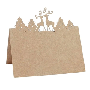 Macro detail of laser-cut reindeer and pine forest on kraft paper place cards
