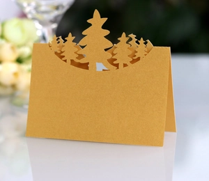 Detail of laser-cut gold Christmas tree place card with shimmering pearlescent finish